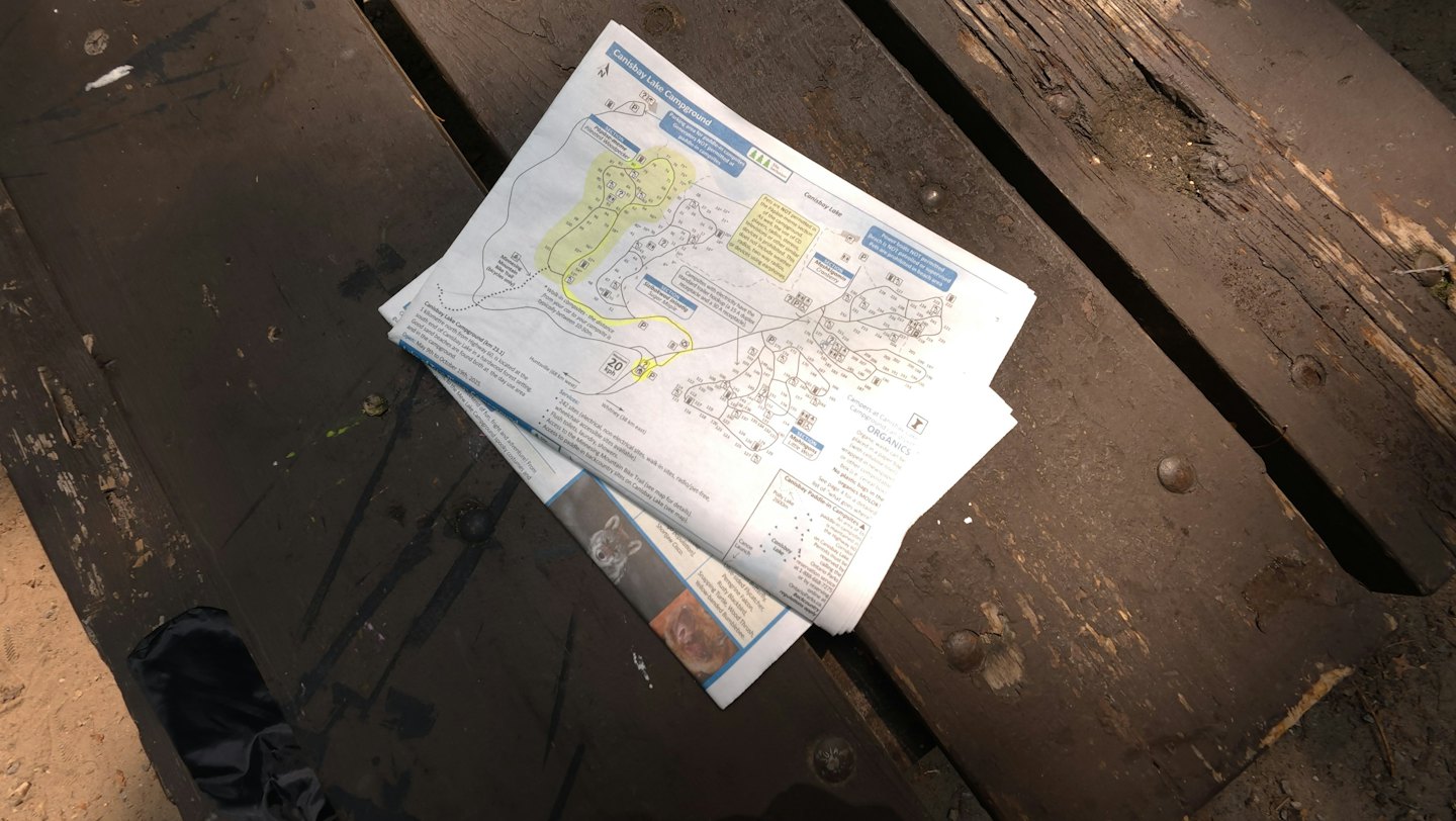 Canisbay Lake Campground map resting on a weathered wooden table.